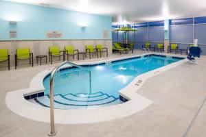 a swimming pool with chairs and tables in a building at SpringHill Suites Denver Parker in Parker