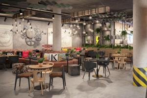 a restaurant with tables and chairs in a room at Moxy Cologne Muelheim in Cologne