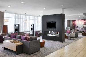 a living room with couches and a fireplace and a tv at Courtyard by Marriott Newark Downtown in Newark