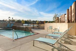 une terrasse avec une piscine, des chaises et une table dans l'établissement Springhill Suites by Marriott Jackson North/Ridgeland, à Ridgeland