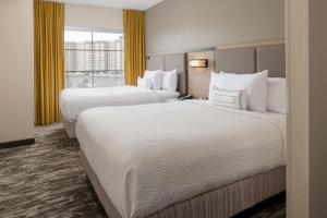 シアトルにあるスプリングヒル スイーツ シアトル ダウンタウンのベッド2台と窓が備わるホテルルームです。