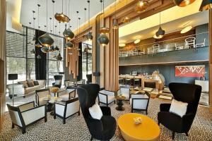 a lobby with chairs and tables and a kitchen at Four Points by Sheraton Doha in Doha