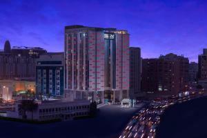 a tall red building with cars in a city at night at Four Points by Sheraton Doha in Doha