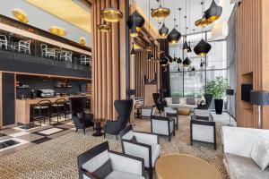 a lobby with chairs and tables and a bar at Four Points by Sheraton Doha in Doha