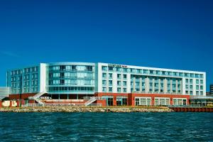 - un grand bâtiment à côté d'une étendue d'eau dans l'établissement Courtyard by Marriott Erie Bayfront, à Érié