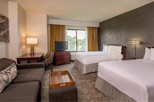 a hotel room with two beds and a couch at SpringHill Suites by Marriott Norfolk Virginia Beach in Virginia Beach