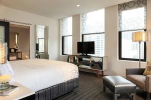 a bedroom with a bed and a tv and a chair at Renaissance Cincinnati Downtown Hotel in Cincinnati