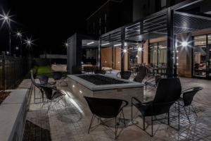een patio met stoelen en 's nachts een vuurplaats bij Courtyard by Marriott East Lansing Okemos in Okemos