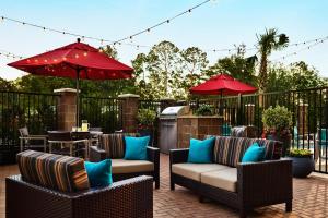 eine Terrasse mit Stühlen und Sonnenschirmen auf einer Terrasse in der Unterkunft TownePlace Suites by Marriott Houston Baytown in Baytown