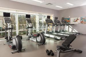 un gimnasio con una fila de cintas de correr y máquinas elípticas en TownePlace Suites by Marriott Houston Baytown en Baytown