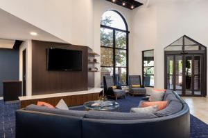 a living room with a couch and a tv at Courtyard La Crosse Downtown/Mississippi Riverfront in La Crosse
