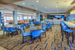 Moorhead的住宿－明尼蘇達州穆爾黑德法戈庭院酒店，一间在房间内配有蓝色椅子和桌子的餐厅