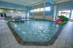 uma piscina interior com um dinossauro na água em Courtyard Fargo Moorhead, MN em Moorhead