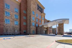 a large brick building with a parking lot in front of it at Fairfield Inn & Suites Dallas Arlington South in Arlington