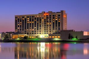 un edificio de hotel con un reflejo en el agua por la noche en Marriott Indianapolis North en Indianápolis