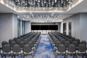 una sala de conferencias con filas de sillas y una pantalla de proyección en Renaissance Oklahoma City Downtown Bricktown Hotel en Oklahoma City