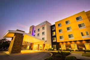 a hotel with a yellow building with a stone pillar at Fairfield Inn & Suites by Marriott Athens I-65 in Athens