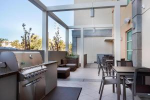 an outdoor patio with a grill and tables and chairs at TownePlace Suites by Marriott San Mateo Foster City in Foster City