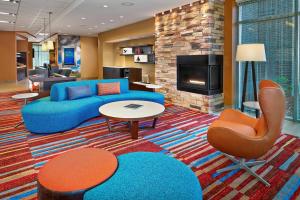 a living room with a blue couch and a fireplace at Fairfield Inn & Suites by Marriott St. John's Newfoundland in St. John's