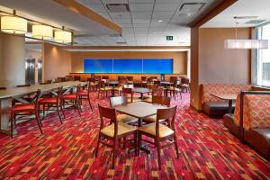 a restaurant with tables and chairs and a large screen at Fairfield Inn & Suites by Marriott St. John's Newfoundland in St. John's