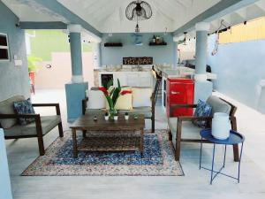 a living room with a table and chairs and a kitchen at Villa Maison de Soleil in Florence Hall