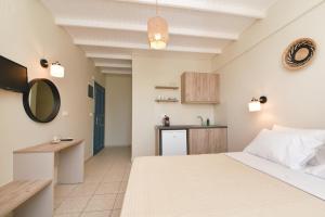 メガス・イアロス・ニテスにあるGlafki Studios Syrosのベッドルーム1室(ベッド1台付)、小さなキッチンが備わります。
