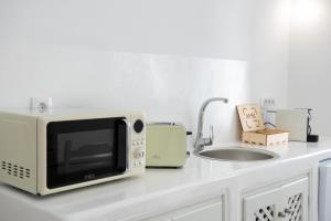 a microwave sitting on a counter next to a sink at Ambi Villas Santorini in Oia