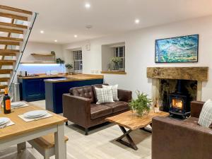 a living room with couches and a fireplace at Ivy Cottage in Falkland