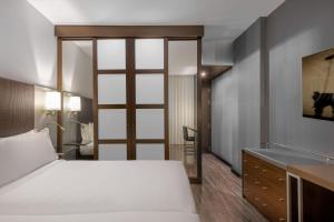 1 dormitorio con cama, escritorio y lavamanos en AC Hotel Coslada Aeropuerto by Marriott, en Coslada