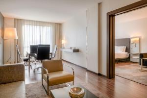 - un salon avec un canapé et une chambre dans l'établissement AC Hotel Coslada Aeropuerto by Marriott, à Coslada