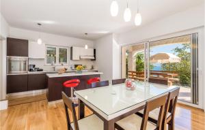 a kitchen and dining room with a table and chairs at Nice Home In Lovran With Sauna in Lovran