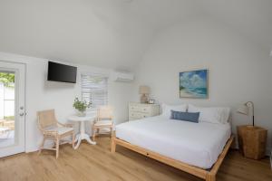 a bedroom with a bed and a table and chairs at Inn on the Beach in Harwich Port