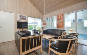 a living room with a couch and a table and chairs at Beautiful Home In Ebeltoft With Sauna, Wifi And Indoor Swimming Pool in Ebeltoft