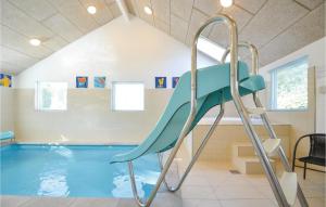 a swimming pool with a slide in a room at Beautiful Home In Ebeltoft With Sauna, Wifi And Indoor Swimming Pool in Ebeltoft