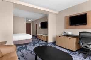 a hotel room with a bed a desk and a tv at Fairfield Inn Kennewick in Kennewick