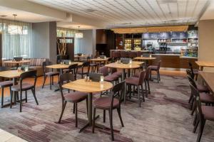 a restaurant with tables and chairs and a bar at Courtyard by Marriott Portland Airport in Portland