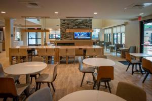 um restaurante com mesas e cadeiras e um bar em Residence Inn by Marriott Pensacola Airport/Medical Center em Pensacola