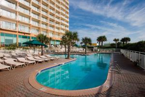 einen Pool mit Liegestühlen und ein Hotel in der Unterkunft Courtyard Carolina Beach in Carolina Beach