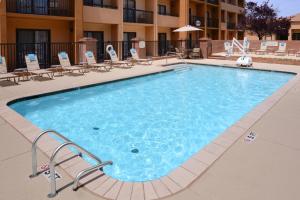 uma grande piscina com cadeiras e um hotel em Courtyard by Marriott Oklahoma City Airport em Oklahoma City