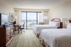 Habitación de hotel con 2 camas y escritorio con TV. en Tampa Airport Marriott, en Tampa