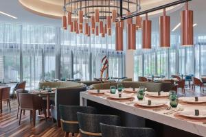 a restaurant with tables and chairs and a chandelier at Art Ovation Hotel, Autograph Collection in Sarasota