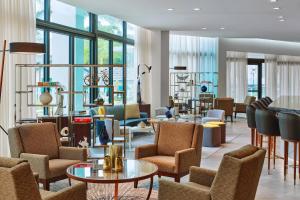 a lobby with chairs and tables and windows at Art Ovation Hotel, Autograph Collection in Sarasota