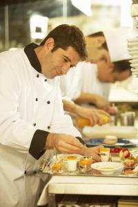 a chef preparing a plate of food in a kitchen at Fairfield Inn & Suites by Marriott Montreal Airport in Dorval