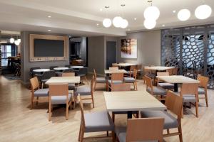a restaurant with tables and chairs and a tv at Fairfield Inn & Suites by Marriott Montreal Airport in Dorval