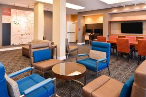 TownePlace Suites by Marriott Huntsville West/Redstone Gateway في هانتسفيل: غرفة انتظار مع كراسي زرقاء وطاولة