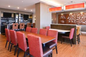 TownePlace Suites by Marriott Huntsville West/Redstone Gateway في هانتسفيل: مطعم بطاولة خشبية وكراسي حمراء
