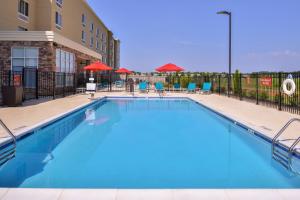 a pool at a hotel with chairs and umbrellas at TownePlace Suites by Marriott Huntsville West/Redstone Gateway in Huntsville