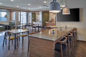 a bar in a restaurant with tables and chairs at Fairfield Inn & Suites by Marriott Louisville Jeffersonville in Jeffersonville