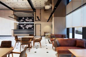 un restaurant avec des tables, des chaises et un écran de projection dans l'établissement Residence Inn by Marriott Istanbul Atasehir, à Istanbul