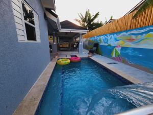 a swimming pool with two frisbees in front of a house at Villa Maison de Soleil in Florence Hall